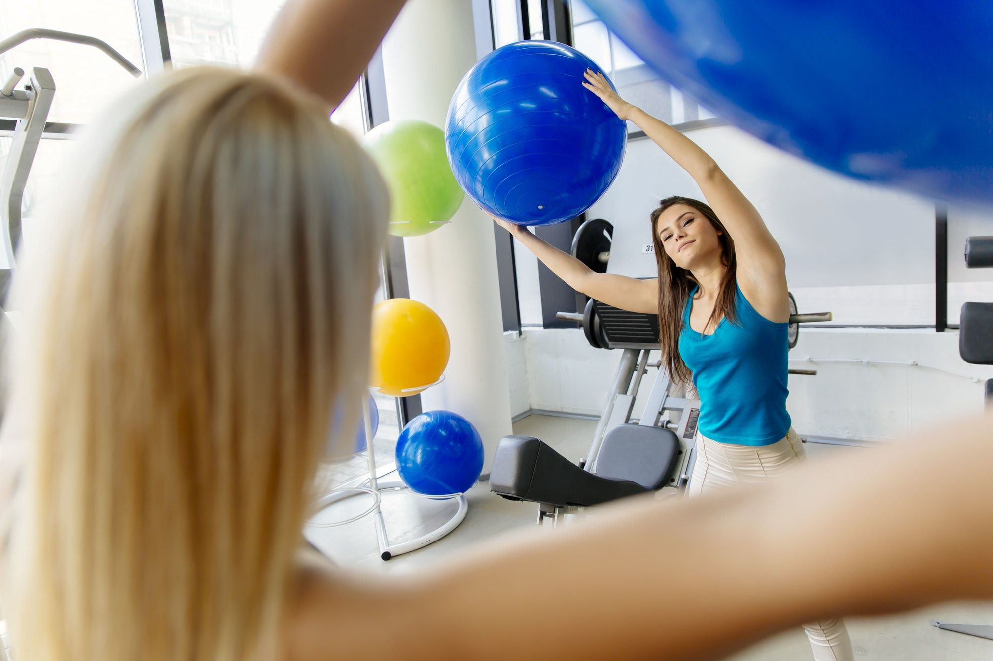 Women, friends training in gym and stretching